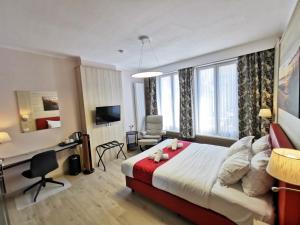 奥斯坦德加的夫酒店的酒店客房设有一张大床和一张书桌。