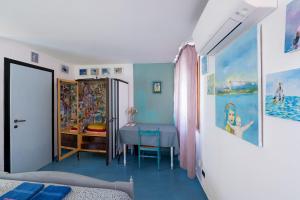 布拉诺岛Night Galleria holiday home - bed & art in Burano - the pink house的卧室配有桌子,铺有蓝色地板