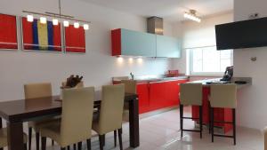 索尔登索尔登皇家公寓酒店的厨房配有红色橱柜和桌椅
