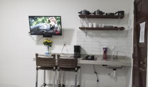 阿拉亚尔达茹达Pousada Bella Vida的一个带柜台的厨房和墙上的电视