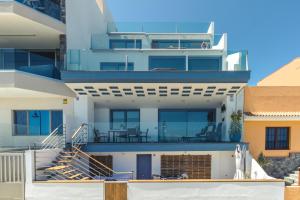 梅莱纳拉Top Views Melenara Beach Avenue Apartments的大型白色房屋设有楼梯和阳台