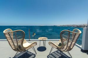 梅莱纳拉Top Views Melenara Beach Avenue Apartments的阳台上配有两把椅子和一张桌子,享有海景