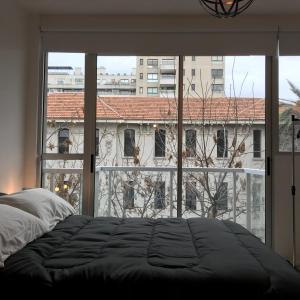 布宜诺斯艾利斯Studio en Palermo Hollywood的卧室设有大窗户,享有大楼的景致。