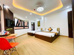 河内A&EM VILLA的酒店客房带两张床和一张桌子以及椅子。