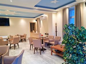 利迈纳里亚Star Bay Luxury的一间设有桌椅的餐厅,以及一间种植了植物的餐厅