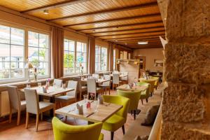 库洛特拉森Hotel Ettrich & Elbresort Rathen的餐厅设有桌椅和窗户。