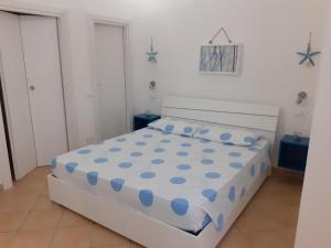 马里迪莫La Dimora Del Vento的一间卧室配有一张带蓝色波卡点的床