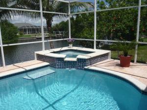 珊瑚角Villa Cape Florida的庭院内带热水浴池的游泳池