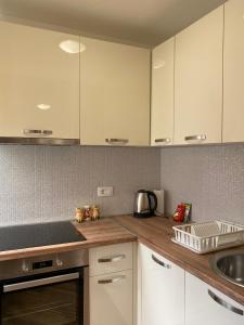 帕里斯特Apartment Jadran的厨房配有白色橱柜和水槽