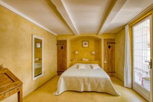 拉卡迪埃达聚Le Mas de la Noria的一间卧室设有一张床和一个大窗户