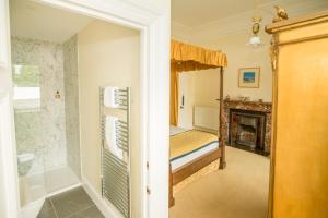 Eaglesfield斯普林克尔旅馆的一间卧室配有一张床和一个壁炉
