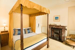 Eaglesfield斯普林克尔旅馆的一间卧室设有一张天蓬床和一个壁炉