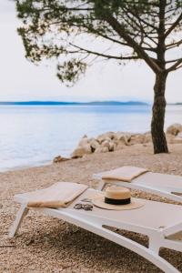 茨里克韦尼察Hotel Miramare的海滩上带帽子和太阳镜的野餐桌