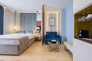 斯普利特Caldo Luxury Rooms的酒店客房,配有一张床和一张蓝色椅子