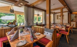 托特瑙Landgasthaus Kurz Hotel & Restaurant am Feldberg - Schwarzwald的餐厅配有木桌和椅子,马匹位于后面
