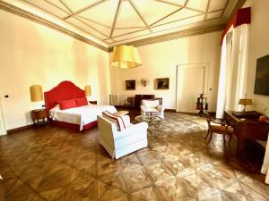 帕多瓦Palazzo Mantua Benavides Suites & Apartments的一间卧室配有一张床、一张沙发和一把椅子