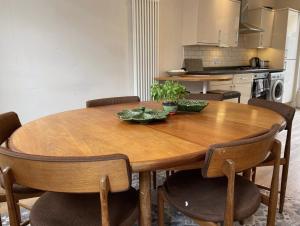 伦敦Central London Charming Camden Split Level Home的厨房里设有一张木桌,周围摆放着椅子
