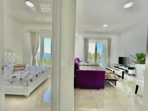 巴尔Seaside Apartments Sword的一间卧室配有一张床和一张紫色沙发