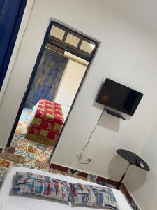 圣多明各Chao Mamá Hostal的一间卧室设有一张床、一台电视和一个窗口。