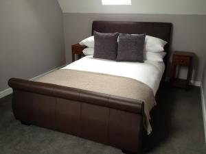 波特里家庭农庄公寓的一张大床,配有棕色床头板和枕头