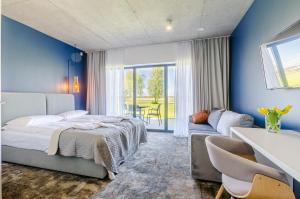 SarbskKite Marina Sarbsk的卧室拥有蓝色的墙壁,配有一张床和一张沙发