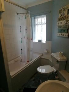 斯沃尼奇Railway Cottage的浴室配有卫生间、浴缸和水槽。