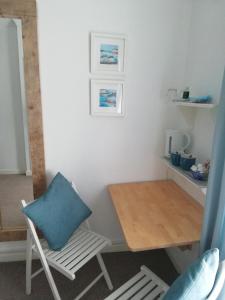 斯沃尼奇Railway Cottage的一张桌子和一把带蓝色枕头的椅子