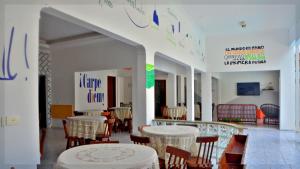 嘎林海斯港Che Lagarto Hostel Porto de Galinhas的大楼内带桌椅的用餐室