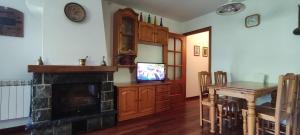 贝纳斯克La Solana del Laball的客厅设有壁炉、桌子和电视