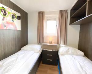 塞罗斯凯尔克Chalet Oceanside Zeeland的小型客房 - 带2张床和窗户