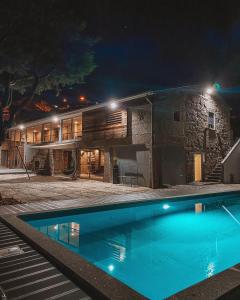 吉马良斯Quinta de Requeixo的一座晚上设有游泳池的房子