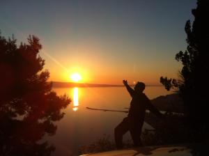 奥米什Villa Panorama的日落时站在湖边的人