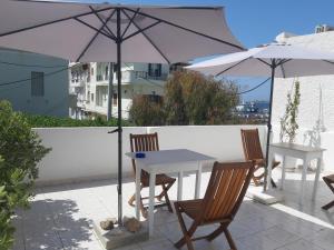 纳克索乔拉Castellino Naxos的庭院内桌椅和遮阳伞
