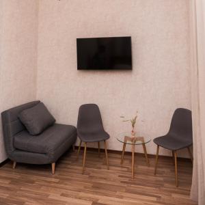 乌曼岛Golden park Apartments的客厅配有两把椅子和电视