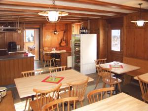RuscheinBoardercamp Laax - swiss mountain hostel的厨房以及带木桌和椅子的用餐室。
