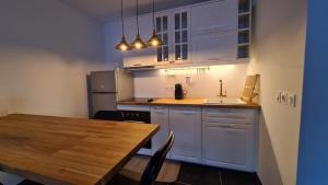 马赛Appartement Plage Prado/Vélodrome的厨房配有白色橱柜和木桌