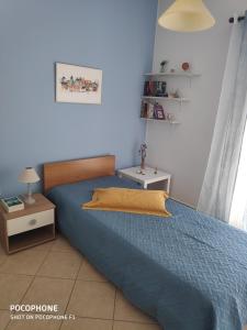 帕莱弗齐亚Anavyssos Cottage的一间卧室配有一张带蓝色棉被的床