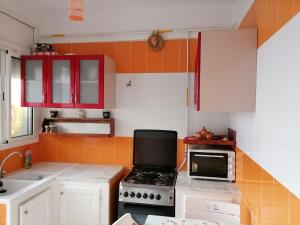 海尔盖莱Hergla_AFH_Beach的厨房配有红色橱柜、炉灶和微波炉