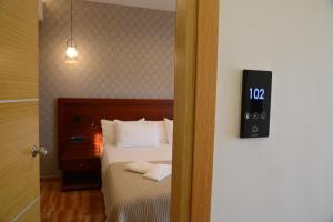 托隆维瑞斯公寓酒店的卧室配有一张床,墙上挂着一个钟