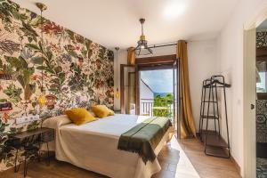 马尔帕尔蒂达德普拉森西亚Apartamentos Rurales Cielo de Monfragüe的一间卧室配有一张带花卉壁纸的床