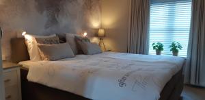 赞德沃特Appartement Marigold的卧室配有一张带白色棉被的大床