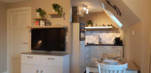 赞德沃特Appartement Marigold的厨房配有平面电视和桌椅。