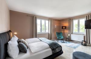辛根PRIMERA Villa的一间卧室配有一张床、一把椅子和窗户。