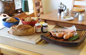 希尔斯维尔拉万达农庄度假屋的一张桌子,上面放着面包和鸡蛋,放在切板上