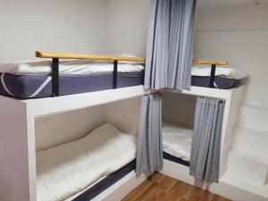 济州市Hannahstay Women Only Guesthouse的小型客房配有两张双层床和窗帘