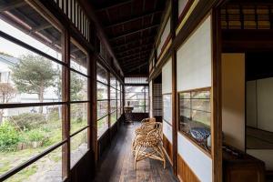 叶山町平野邸 Hayama的走廊上设有窗户和椅子