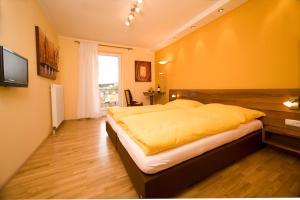 MünzkirchenGasthof Wösner的一间卧室配有一张带黄色毯子的大床