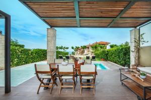 卡尼奥提Sunny Villas Exclusive的一个带桌椅的庭院和一个游泳池