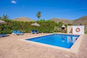 波连萨港Villa Can Serra的一个带2把蓝色椅子的游泳池,一个度假胜地