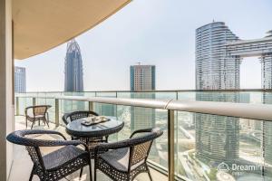 迪拜Dream Inn Dubai Apartments- Burj Vista的阳台配有2把椅子和桌子